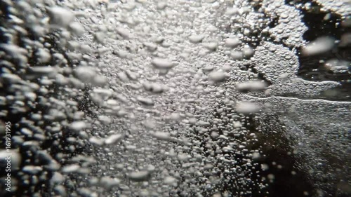 a Lot of Bubbles Underwater Close to Surface of Water Camera Goes up Sky With Clouds photo