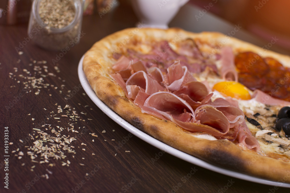 Hot pizza slice with melting cheese on a rustic wooden table. Fresh pizza with tomatoes, cheese and mushrooms on wooden table close up. Hot pizza slice with melting cheese on a rustic wooden table. Fresh pizza with tomatoes, cheese and mushrooms on wooden table close up.