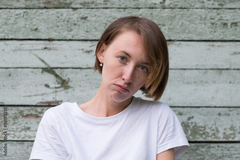 portrait of beautiful young angry woman in white t-shirt