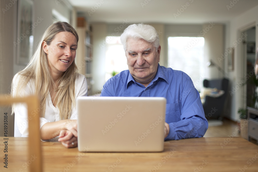 Girl showing her grandad how the computer works Girl showing her grandad how the computer works