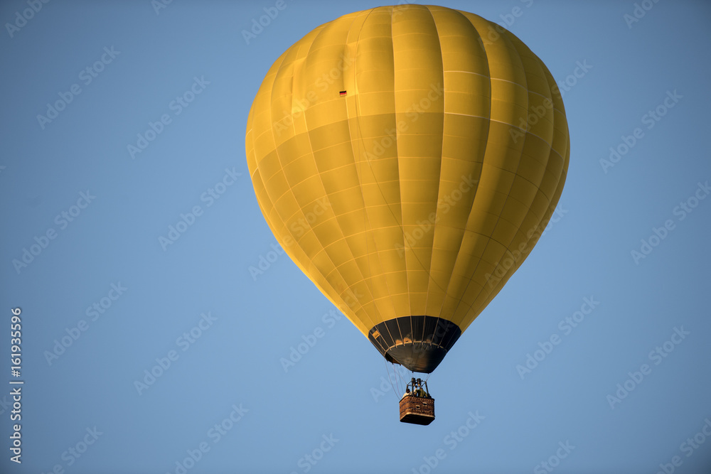 Fototapeta premium gelber Heissluftballon vor blauem himmel