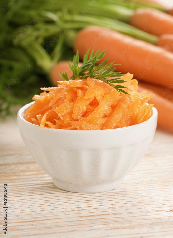 grated carrot on wooden background grated carrot on wooden background