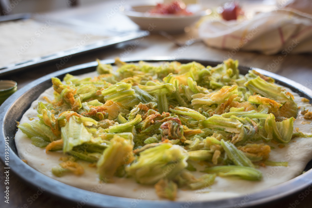 making pizza with zucchini flowers