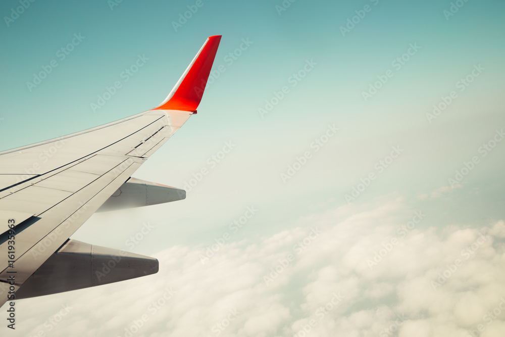 Fototapeta premium Cloudy sky with wing of airplane, vintage style background