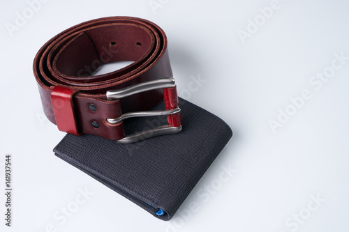 Stylish men accessories. Notebook, brown leather belt and a black wallet on a white background.