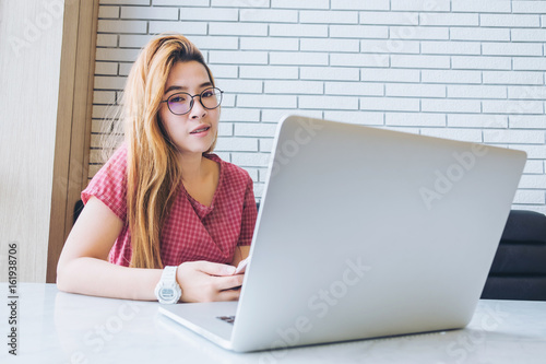 Asian girl working at a coffee shop with a laptop.female freelancer connecting to internet
