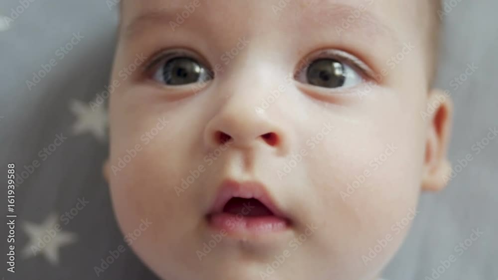 infant lies on back with open big eyes infant lies on back with open big eyes
