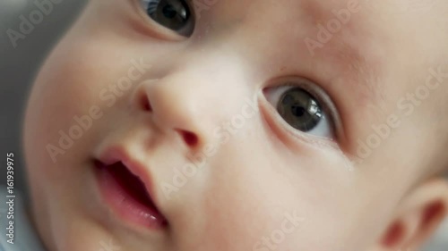 infant lies on back with open big eyes