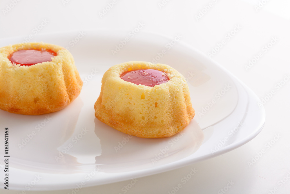 couple of the cookies with strawberry jam on the white plate. Time of tea couple of the cookies with strawberry jam on the white plate. Time of tea