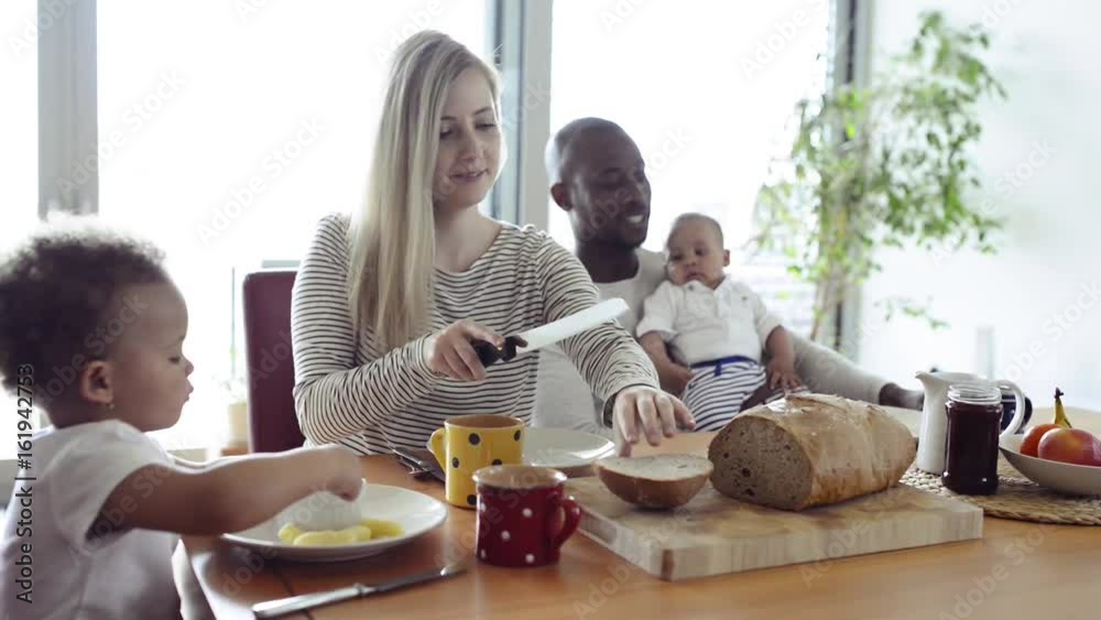Young interracial family with little children having breakfast. Young interracial family with little children having breakfast.