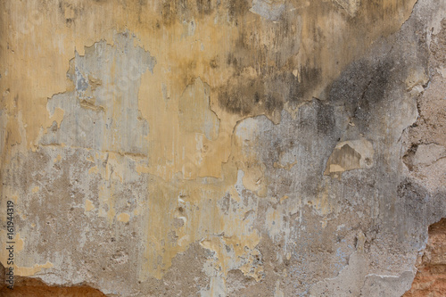 Verwitterte Wand mit gelbem Anstrich
