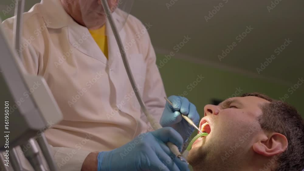 Dentist Water Rinses the Oral Cavity of the Patient After Removal of Calculus Dentist Water Rinses the Oral Cavity of the Patient After Removal of Calculus