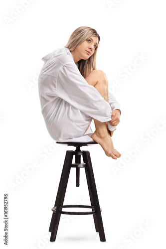 Sad young woman sitting on a chair