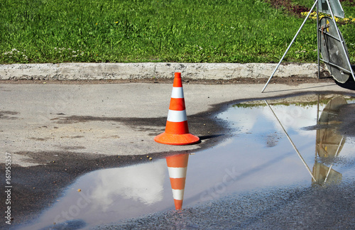 plastic signaling traffic cone encloses a place in the parking lot for trucks.