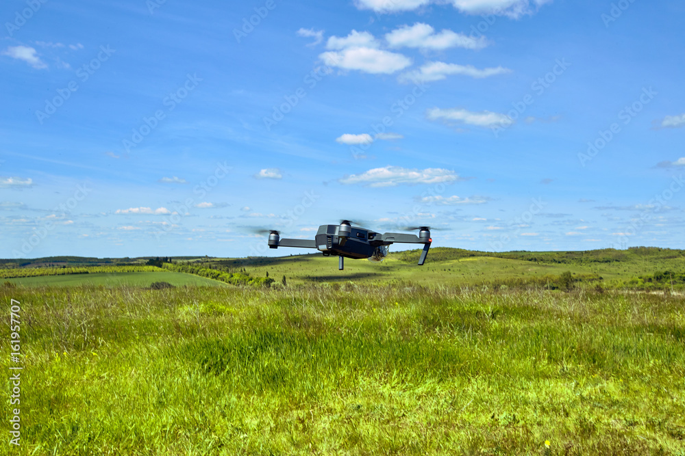 Flight of a gray quadrocopter against a blue sky. Flight of a gray quadrocopter against a blue sky.