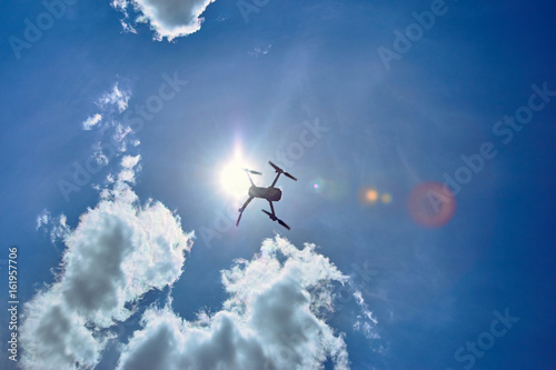 Fototapeta Naklejka Na Ścianę i Meble -  Flight of a gray quadrocopter against a blue sky.