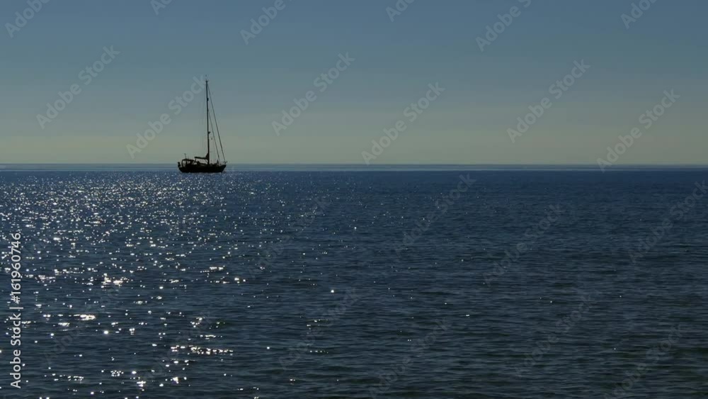 Sailing boat floating on water in Italy. Italian coast in Sardinia on Mediterranean Sea. Early morning in Sardegna, Italia Sailing boat floating on water in Italy. Italian coast in Sardinia on Mediterranean Sea. Early morning in Sardegna, Italia