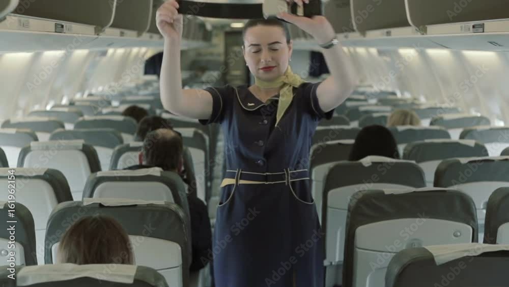 Brunette stewardess shows manipulations with seat-belt