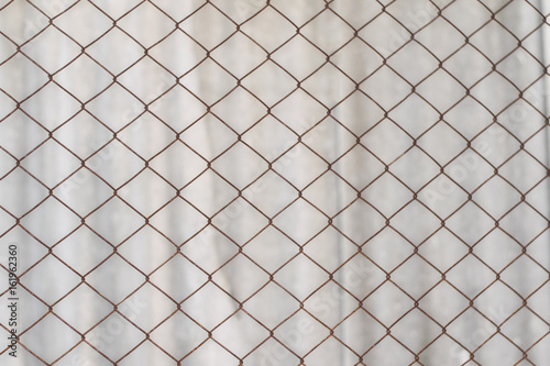 Texture of an old rusty mesh. Metal net on white background