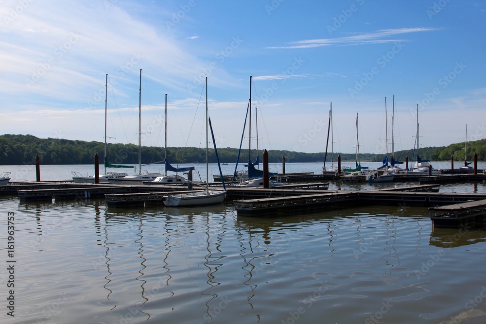 The docked boats at the lake on a sunny day.