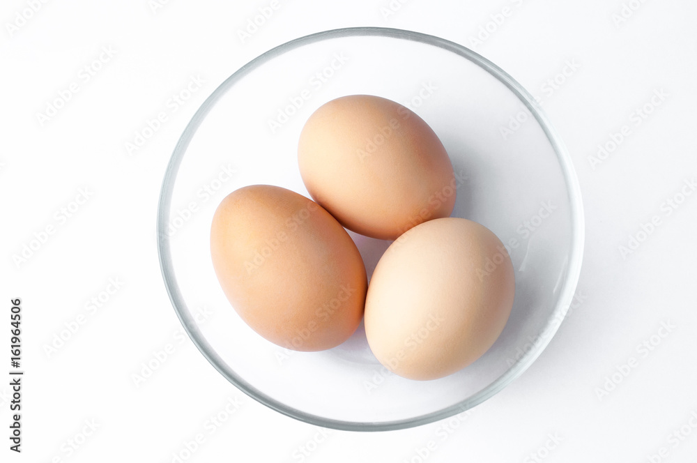 brown eggs in glass bowl on white background brown eggs in glass bowl on white background