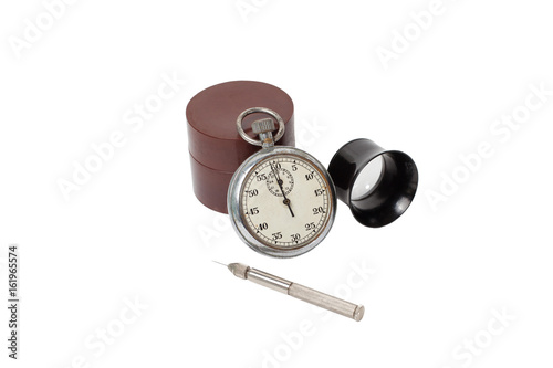 Antique mechanical stopwatch and clockmaker toolset on white background