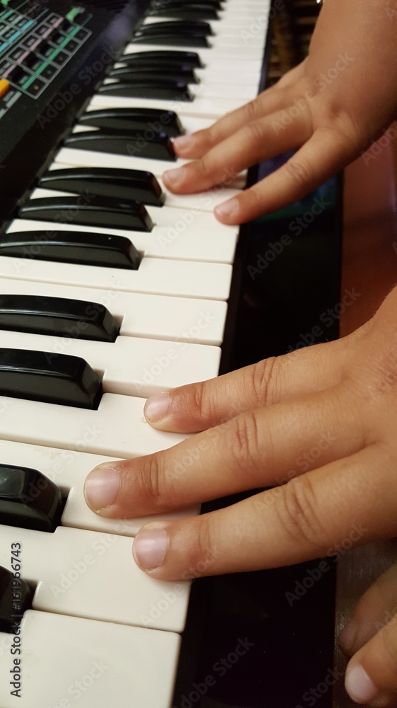 Obraz premium Mani di bambina che suonano la pianola