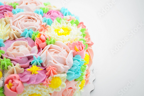 Cake with color cream flowers on white background. Picture for a menu or a confectionery catalog. Close-up.