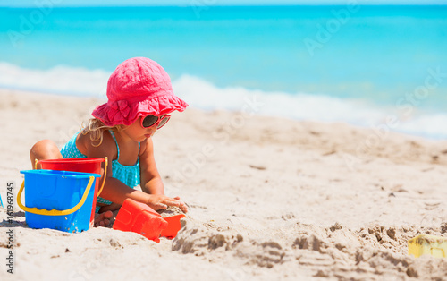 cute little girl play with sand on beach © nadezhda1906