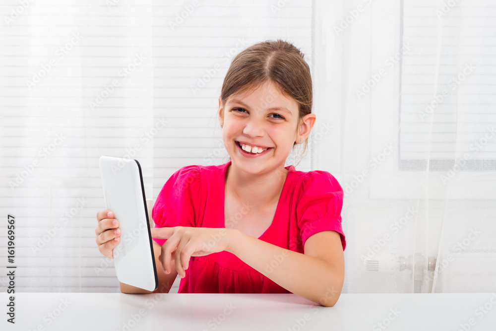Little girl using digital tablet at her home. Little girl using digital tablet at her home.
