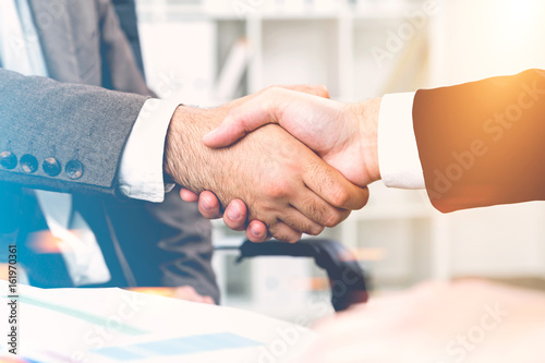 Close up of two men shaking hands in office