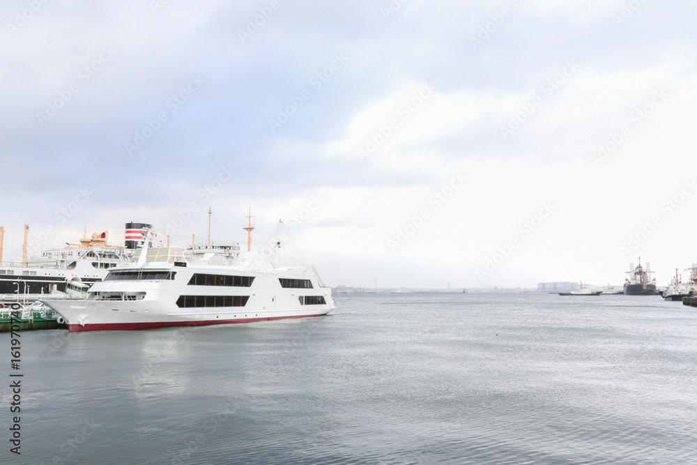 White travel cruise vessel on the left of frame with sky background