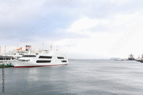 White travel cruise vessel on the left of frame with sky background