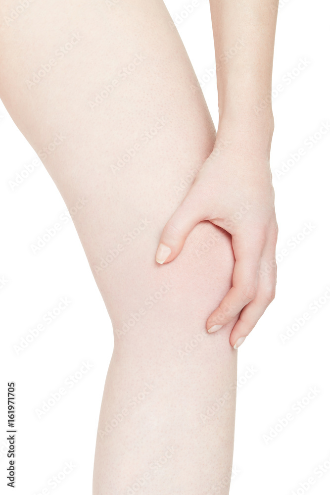 Young woman holds her hand on knee, pain isolated on white, clipping path