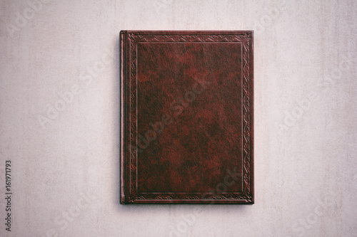 the book in a red cover on a light gray background, top view