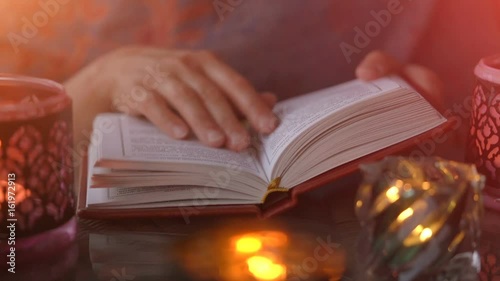 Woman reading book with candle lights photo