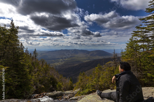 Man sitting and looking out from elevation on Mount Washinton via Ammonoosuc ravine trail