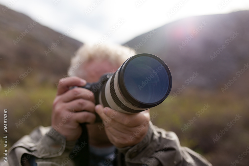 Photographer takes a photo with a large lens