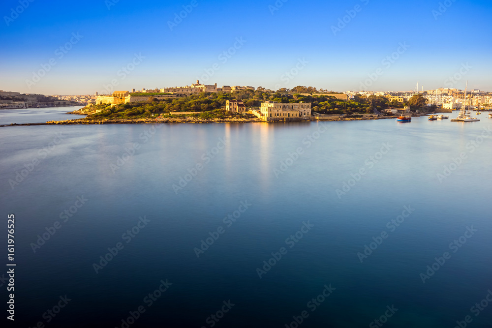 Valletta, Malta - Summer sunrise view with Manoel island, Valletta and Sliema with sailing boats and clear blue sky