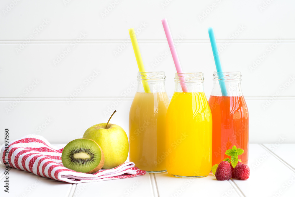 Collage of glasses with fresh delicious smoothie juice and straw on board background colourful for kids party