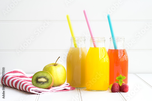 Obraz na płótnie Collage of glasses with fresh delicious smoothie juice and straw on board background colourful for kids party w salonie