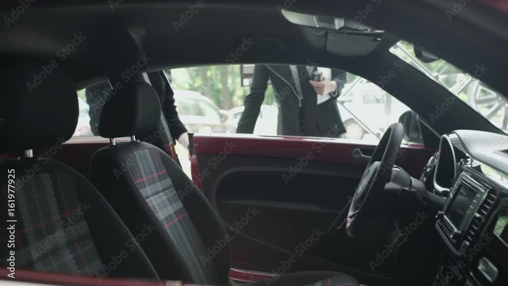 The manager invite the customer to test the car cabin The manager invite the customer to test the car cabin