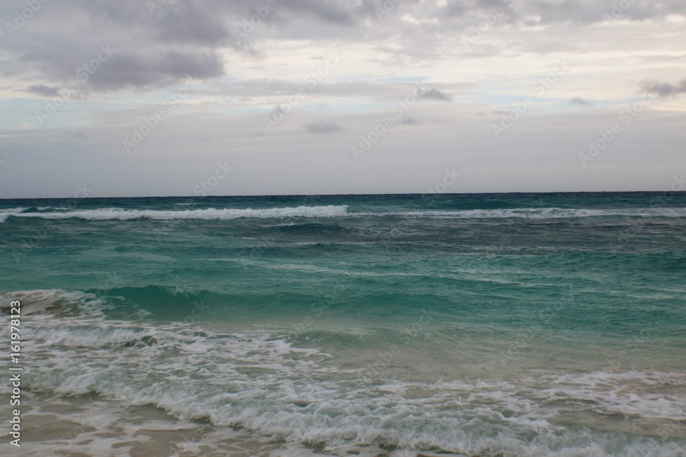 Paradise beach,Cuba. View of a perfect desert coast with withe sand and blue turquoise sea in a cloudy day Paradise beach,Cuba. View of a perfect desert coast with withe sand and blue turquoise sea in a cloudy day