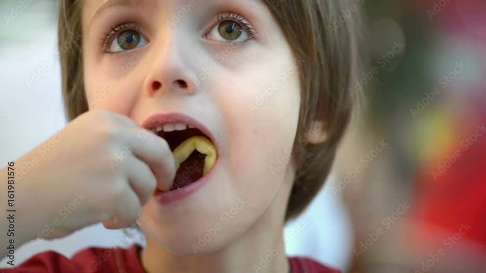 Happy kid eating fried potato in a restaurant Happy kid eating fried potato in a restaurant
