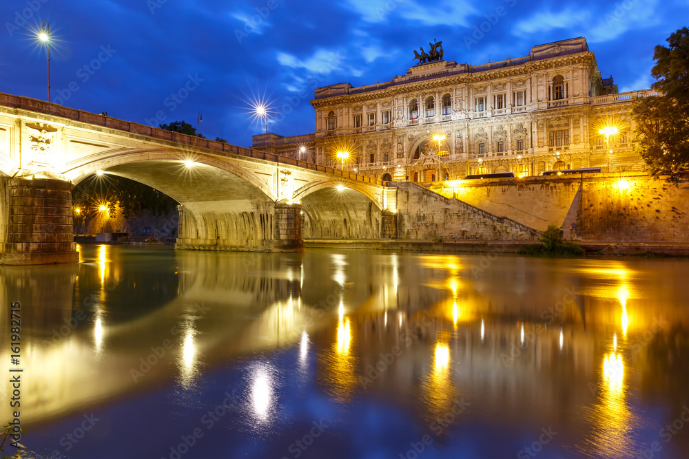 The Palace of Justice and bridge Ponte Umberto I with mirror reflection in Tiber River during morning blue hour in Rome, Italy