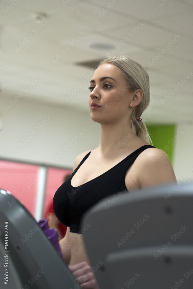 A beautiful young woman exercising on a treadmill at the gym A beautiful young woman exercising on a treadmill at the gym