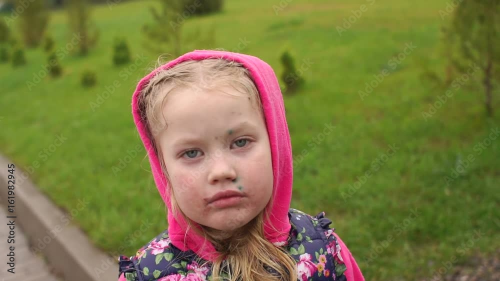 Portrait of sad little girl with chicken pox and allergies on the face stands in the rain on the street. Portrait of sad little girl with chicken pox and allergies on the face stands in the rain on the street.