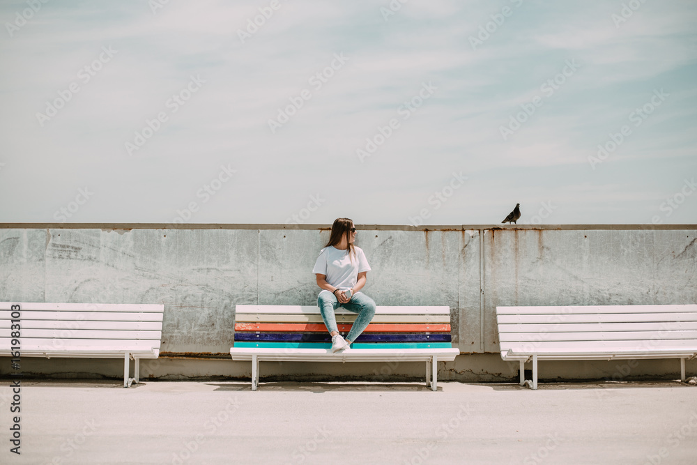 Beautiful woman on the beach with a mobile and a bird