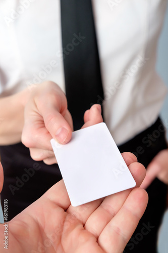 employee of the bank offers a plastic card  close up  copy space. Buisness woman showing plastic credit card or business card