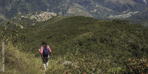 Person looking a town in middle of the mountains photo